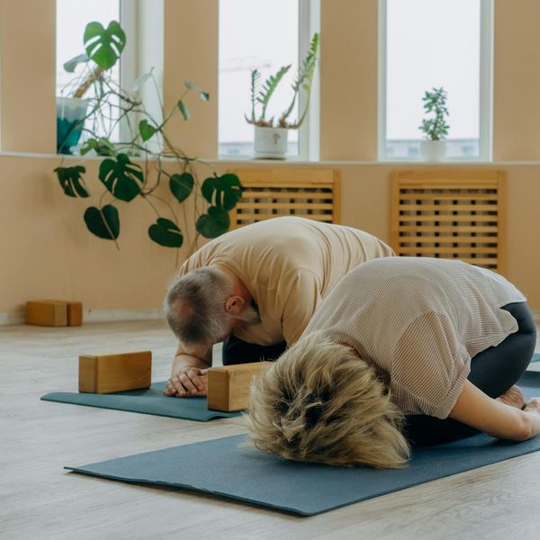 Group of men doing a balancing yoga pose together.